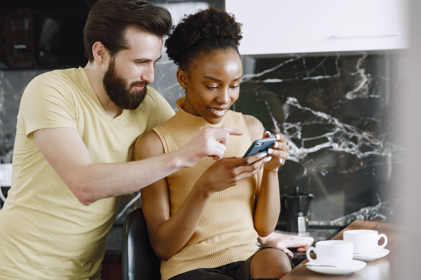 Friends looking at a phone together, representing NLOM's Facebook & Instagram channel
